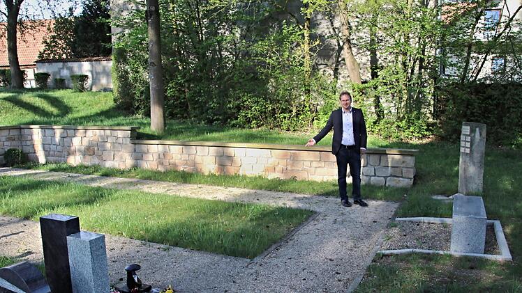 Es ist bereits ein Urnenfeld vorhanden, wie hier Bürgermeister Wolfram Thein zeigt. Vor der Mauer hinter Thein sollen anonyme Bestattungen stattfinden.