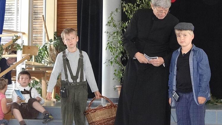 Die Kinder waren neugierig, wie der Mann, der ihrer Schule den Namen gegeben hat, gelebt hat. Pater Alfons Blüml (Mitte) hat es ihnen erzählt. Foto: Johanna Eckert