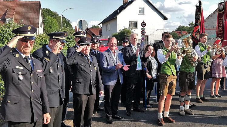 Bezirkstagspräsident Erwin Dotzel (Mitte links) und Münnerstadts Bürgermeister Helmut Blank (Mitte rechts) applaudieren gemeinsam mit Feuerwehr-Kommandanten und der Musikgruppe "Schütt die Brüh noo" dem Jubiläumsfestzug. Foto: Sigismund von Dobschütz