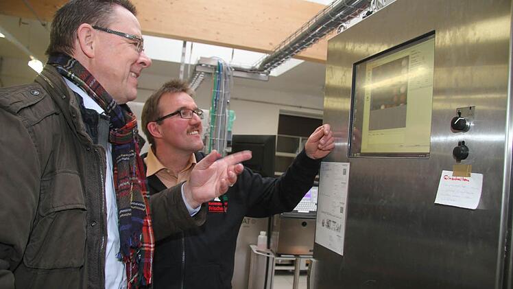 Klaus Schiffer-Weigand vom Amt für Ernährung, Landwirtschaft und Forsten lässt sich vom Unternehmer Hans-Peter Kolb die Funktionsweise der Maschine erklären: Im Monitor wird angezeigt, welche Eier in Ordnung sind - sie sind mit einem grünen Kästchen gekennzeichnet. Foto: Sonja Adam