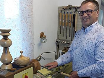 Reinhard Vogler in seiner Werkstatt. Auf der Drechselbank stehen zwei seiner Kunstwerke: ein Kerzenständer und eine Dose.  Foto: Heidi Amon
