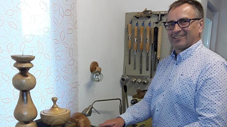 Reinhard Vogler in seiner Werkstatt. Auf der Drechselbank stehen zwei seiner Kunstwerke: ein Kerzenständer und eine Dose.  Foto: Heidi Amon