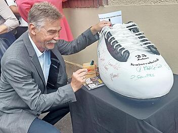 Hans-J&uuml;rgen Heinzel sowie viele G&auml;ste signierten den Herzo-Schuh, den die Mitglieder des Seniorenbeirats der VHS abgeluchst hatten.