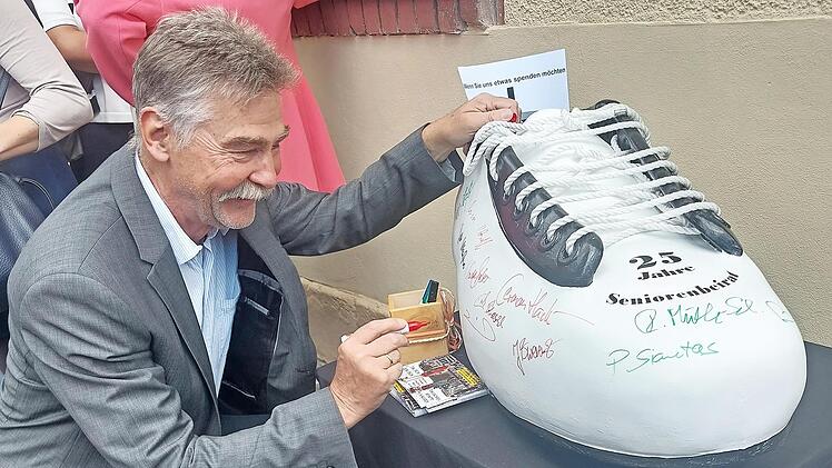 Hans-J&uuml;rgen Heinzel sowie viele G&auml;ste signierten den Herzo-Schuh, den die Mitglieder des Seniorenbeirats der VHS abgeluchst hatten.