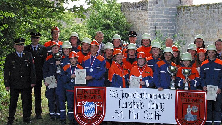 So sehen Sieger aus: Beim diesjährigen Kreisjugendleistungsmarsch holten die Jugendgruppen Großwalbur 1, Seßlach/Hattersdorf/Merlach, Bad Rodach und Gemünda/Autenhausen die Pokale. Als Erstplatzierte des A-Teils freuten sich die Zweierteams von Niederfüllbach, Scherneck und Bad Rodach über ihre Medaillen (Bildvordergrund). Kreisbrandrat Michael Lorenz (links) sowie Seßlachs Bürgermeister Martin Mittag, Kreisjugendwart Stefan Wunder und Ulrich Böhm (Sparkasse Coburg-Lichtenfels, im Hintergrund...