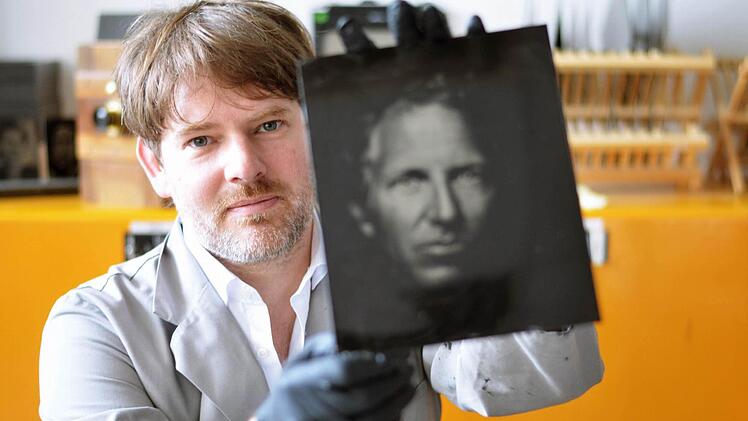 Peter Kunz mit einem neuen Kollodium-Foto direkt aus der Dunkelkammer. Foto: Nikolas Pelke