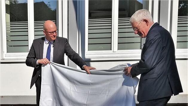 Dr. Josef Schuster (rechts), Präsident des Zentralrats der Juden in Deutschland, enthüllt gemeinsam mit Oberbürgermeister Dr. Dirk Vogel (SPD) am Platz der einstigen Synagoge die von Berufsschülerin Takayo Miura gestaltete hölzerne Gepäckrolle. Foto: Sigismund von Dobschütz