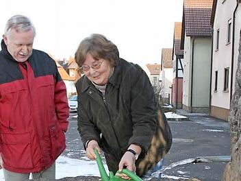 Der Dorfbrunnen in Reichenbach wird auch weiterhin aus dem Wasser des ehemaligen Reichenbacher Trinkwasserbrunnens gespeist. Arnold Nöth und Gunda Tüchert wissen, dass das Brauchwasser gut fürs Gießen geeignet ist, weil es kalkarm ist. Foto: Heike Beudert