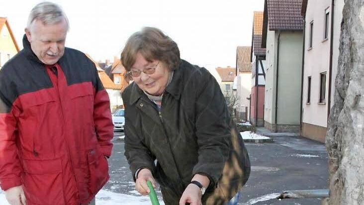Der Dorfbrunnen in Reichenbach wird auch weiterhin aus dem Wasser des ehemaligen Reichenbacher Trinkwasserbrunnens gespeist. Arnold Nöth und Gunda Tüchert wissen, dass das Brauchwasser gut fürs Gießen geeignet ist, weil es kalkarm ist. Foto: Heike Beudert