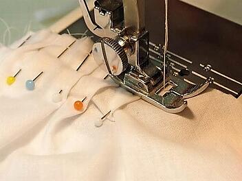 Die Fältchen auf der Schulter werden mit einem langen Stich auf der Nähmaschine auf jedem Ärmelteil fixiert, der Stoff kann schnell verrutschen.