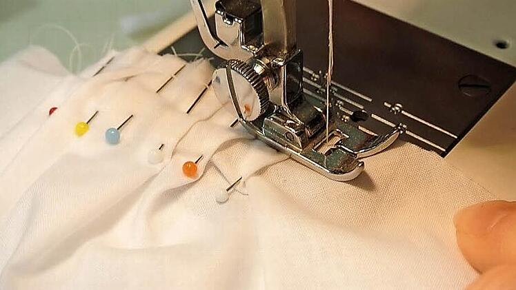 Die Fältchen auf der Schulter werden mit einem langen Stich auf der Nähmaschine auf jedem Ärmelteil fixiert, der Stoff kann schnell verrutschen.