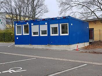 Die Haßfurter Grundschule an der Dr-Neukam-Straße (im Hintergrund) mit der Mittagsbetreuung, die übergangsweise Container hingestellt bekam: Die Grundschule soll  in den nächsten Jahren um je zwei Klassenzimmer und Gruppenräume erweitert werden. Die Container verschwinden wieder, wenn die geplante Mittagsbetreuung am Schulhaus Nassachtal fertig ist.Brigitte Krause