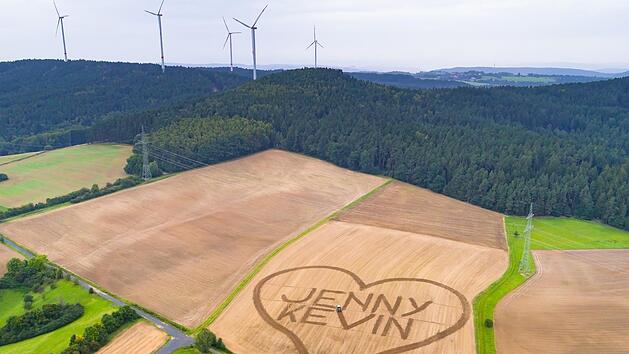 Kevin Wolf aus Danndorf macht seiner Jenny einen XXL-Heiratsantrag. Auf der Fl&auml;che von zwei Fu&szlig;ballfeldern hat er seine Botschaft gegrubbert. Im Hintergrund der Spitzberg bei Schimmendorf/G&auml;rtenroth und die Windr&auml;der von Hain. Foto:  Ingo B&auml;uerlein/frankenair.de