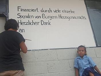 Nach dem Bau der ersten Schule bedankte sich die Dorfbevölkerung bei den Spendern aus Herzogenaurach mit einem Schild (l.). Alberto Parmigiani sammelt auch beim vierten "Rock for Nepal" Spenden für Erdbebenopfer.   Foto: privat