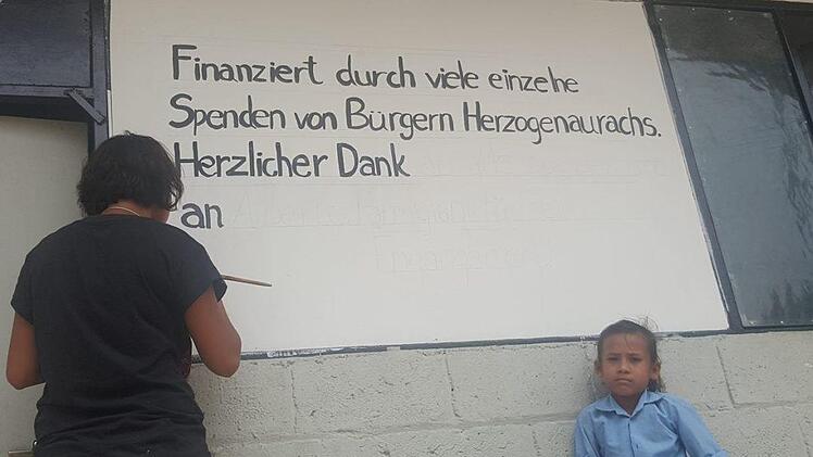 Nach dem Bau der ersten Schule bedankte sich die Dorfbevölkerung bei den Spendern aus Herzogenaurach mit einem Schild (l.). Alberto Parmigiani sammelt auch beim vierten "Rock for Nepal" Spenden für Erdbebenopfer.   Foto: privat
