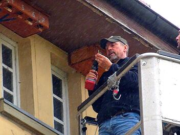 Alex Brand befestigt die Nistkästen unter dem Dach der alten Schule in Hetzlos. Foto: Martina Faber