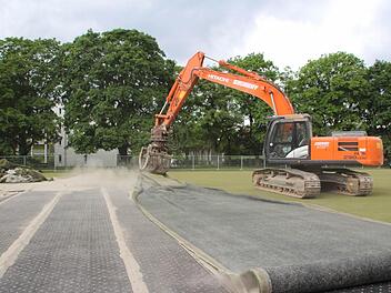 Der verschlissene Kunstrasen wird "eingerollt". Am 10. Juni ist hier Grundsteinlegung für das neue BRK-Pflegezentrum. Foto: Ekkehard Roepert