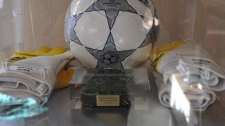 Ein Stück Originalrasen des WM-Finales 2006 in Berliner Olympiastadion. Daneben: Die Handschuhe von Manuel Neuer und Andreas Köpke