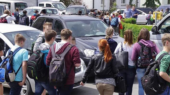 Minutenlang steht der Lieferwagen (hinten links) am Anstieg der Gabelsberger Straße. Nichts geht mehr, weil die Autos von falsch parkenden Eltern, rücksichtslos auf der Straße laufende Schüler und der in diesem Chaos feststeckende Gegenverkehr den "Flaschenhals" an der Kreuzung verstopfen.