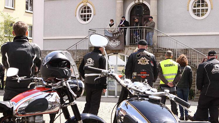 Zwei alte "Schlachtrösser" während der Motorrad-Segnung - die NSU und die Horex: Vom erhöhten Standort vor dem Rathaus blicken Bürgermeisterin Brigitte Meyerdierks, Dekan Michael Krammer, Manfred "Hembo" Hembacher, und die musikalische Unterstützung Mike Ryan auf die versammelte Gemeinde. Foto: Thomas Dill