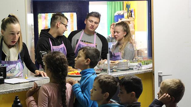 Kerstin Waldvogel (links im Bild) und Sch&uuml;ler verteilen Essen an die hungrigen Kinder. &nbsp; Fotos: Kevin Cegla
