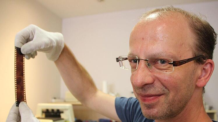Selbst mit Negativstreifen hat Peter Niemzick in seinem Foto-Shop in der Webergasse gelegentlich noch zu tun. Doch weil sich das Fotografierverhalten der Menschen ganz grundsätzlich sehr gewandelt hat, muss er sein Geschäft nun schließen.Foto: Oliver Schmidt