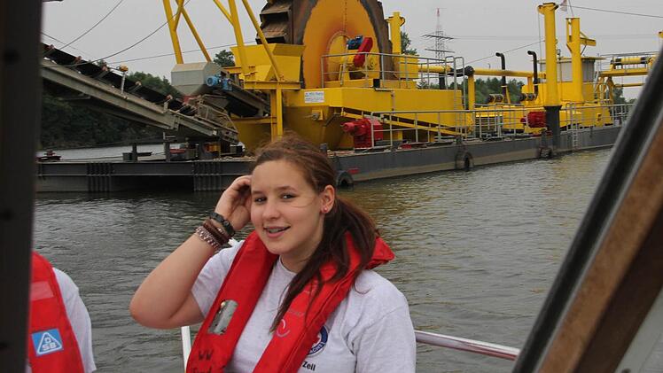 So macht die Arbeit Spaß: Im Bug des Rettungsschiffes fährt Vanessa Lang auf dem Main bei Sand an einem Schwimmbagger vorbei.