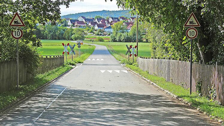 So würde man Autofahrer optisch besser auf den Schienenübergang aufmerksam machen, schlägt ein Verkehrsexperte aus Bergisch-Gladbach am Bahnüberweg in Lind vor: mit aufgemalten Haifischzähnen auf der Fahrbahn. Fotomontage: Franziska Schäfer/Ralf Kestel