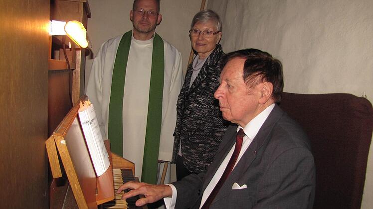 Flink gleiten Walter Dorns Finger über das Manual. Marie-Luise Plack vom Kirchenvorstand und Pfarrer Hans-Jürgen Pöschl freuen sich über die treuen Dienste des Coburger Kirchen- und Jazzmusikers - und das seit 50 Jahren. Foto: Martin Koch