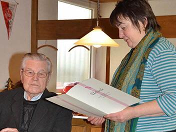 Sichtlich gerührt nahm Altbürgermeister und Ehrenbürger des Marktes Pressig, Josef Wich, die Auszeichnung mit der roten Ehrennadel der KAB entgegen. Diözesansekretärin Maria Gerstner verlas die Ehrenurkunde.   Foto: Karl-Heinz Hofmann