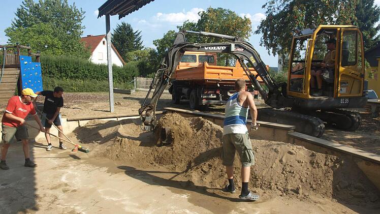 Auf dem Freispielgelände der Kindertagesstätte Rottershausen wurde der Sand im großen Spielkasten ausgetauscht. Unser Foto zeigt (von links) die Helfer Thomas Schmitt, Thorsten Seufert und Markus Seufert sowie Mario Parente auf dem Bagger.  Fotos: Stefan Geiger