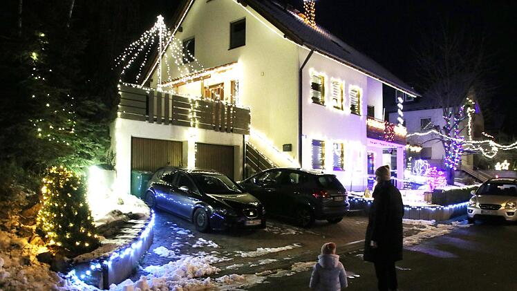 Mutter und Tochter bewundern in der Frankenstraße in Mühlendorf ein Weihnachtshaus - auch der Nachbar gegenüber hat sein Anwesen geschmückt. Foto: Schanz