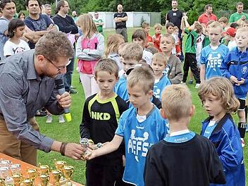 Schirmherr Simon Ehnes überreicht einen Pokal an den G-Jugendlichen des FC Redwitz, Marlon Schmitter. Fotos: Thomas Micheel