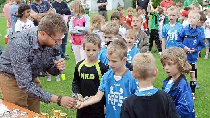Schirmherr Simon Ehnes überreicht einen Pokal an den G-Jugendlichen des FC Redwitz, Marlon Schmitter. Fotos: Thomas Micheel