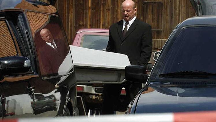 Abtransport der Leiche. Das Archivfoto aus einer bayerischen Gemeinde steht symbolhaft für die Abgründigkeit auch des ganz normalen Bürgers. Kaum eine Woche, in der wir nicht von Mordfällen aus dem herkömmlichen Alltag erfahren müssen. Neil LaButes Stück blickt in die Gesichter "ganz normaler" Bürger, die zu Mördern wurden.  Foto: Armin Weigel dpa/lby