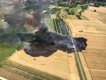 Ballenpresse und Feld in Brand geraten