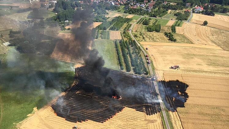 Ballenpresse und Feld in Brand geraten