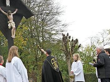 Pfarrer Matthias Steffel bei der Weihe des sanierten Friedhofskreuzes in Hallerndorf  Foto: Mathias Erlwein