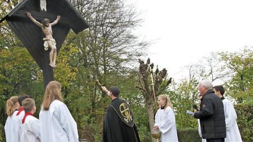 Pfarrer Matthias Steffel bei der Weihe des sanierten Friedhofskreuzes in Hallerndorf  Foto: Mathias Erlwein