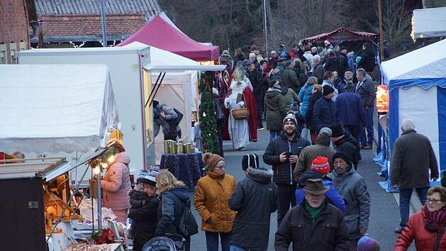 Als die D&auml;mmerung hereinbrach und Lichter und Fackeln auf dem Gel&auml;nde rund um die Pfarrkirche angez&uuml;ndet wurden, f&uuml;llte sich der Weihnachtsmarkt in Gro&szlig;wenkheim. Anton Then