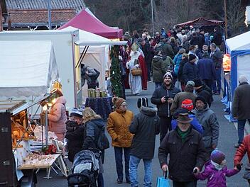 Als die Dämmerung hereinbrach und Lichter und Fackeln auf dem Gelände rund um die Pfarrkirche angezündet wurden, füllte sich der Weihnachtsmarkt in Großwenkheim. Anton Then