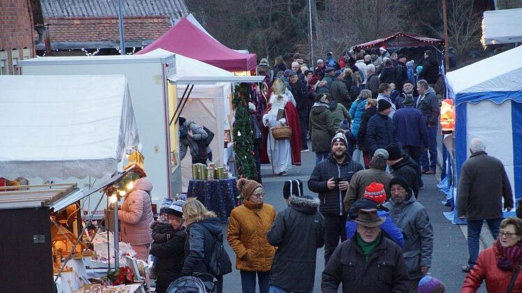 Als die Dämmerung hereinbrach und Lichter und Fackeln auf dem Gelände rund um die Pfarrkirche angezündet wurden, füllte sich der Weihnachtsmarkt in Großwenkheim. Anton Then