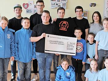 Die Kinderfeuerwehr "Florianskäfer" mit Gruppenleiterin Hildegard Brasch (links) freute sich über den Besuch der Dorfjugend Dietersdorf, die ihre Arbeit mit 150 Euro unterstützen.  Foto: Carsten Höllein