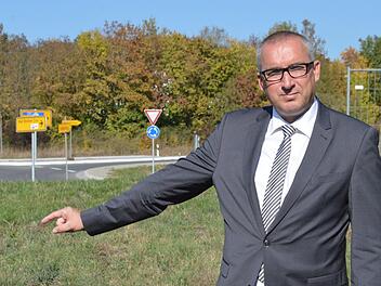 Unweit des Aschacher Kreisverkehrs (im Hintergrund) soll ein neuer Einkaufsmarkt der Rewe-Gruppe entstehen.  Im Bild Bürgermeister Andreas Sandwall auf dem betreffenden Grundstück.  Foto: Archiv/Isolde Krapf