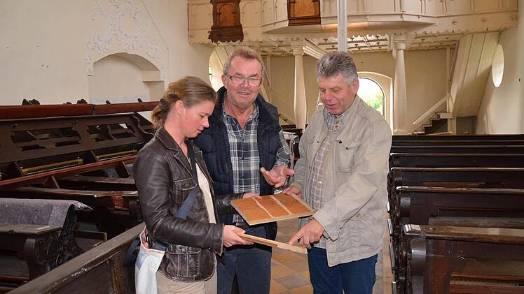 Kirchenpfleger Heinrich Nüßlein (rechts im Bild) mit Josef Denzlein, zuständig für die Schreiner und Holzarbeiten in der Kirche, und Diözesanarchitektin Petra Postler bei der Bemusterung des Holzes für die Bankpodeste. Foto: Andrea Spörlein