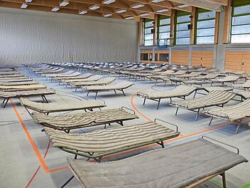 Stunden vor der Ankunft der ersten Asylbewerber in Neustadt stehen zumindest Feldbetten in der Frankenhalle bereit. Hier für Wochen auf engstem Raum mit 170 Menschen zu übernachten, hat mit Komfort wenig zu tun.