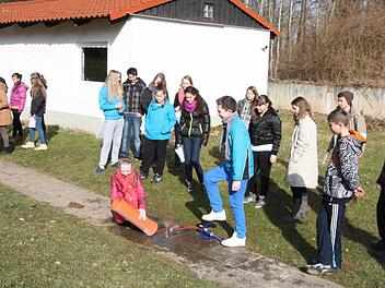 Schüler aus Delmenhorst und aus Karvan erleben gemeinsam, wie das Rückstoßprinzp funktioniert.  Foto: Edgar Bartl
