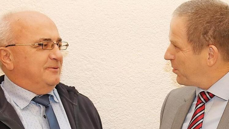 Rainer Mattern überreicht Jürgen Friedrich (links) die kommunale Dankurkunde.