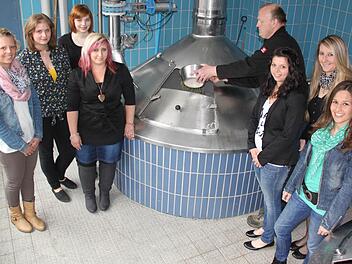 Der Staffelsteiner Feuerwehrkommandant Michael Ludwig füllt den Hopfen in die Sudpfanne des Frauendorfer Brauhaus - ihm assistieren dabei jene Frauen, die das Feuerwehrjubiläum im Mai als Ehrendamen begleiten werden. Foto: Matthias Einwag