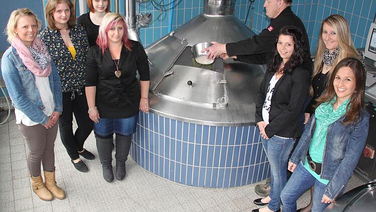 Der Staffelsteiner Feuerwehrkommandant Michael Ludwig füllt den Hopfen in die Sudpfanne des Frauendorfer Brauhaus - ihm assistieren dabei jene Frauen, die das Feuerwehrjubiläum im Mai als Ehrendamen begleiten werden. Foto: Matthias Einwag